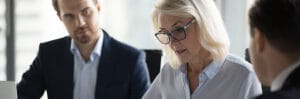 Concentrated aged businesswoman checking agreement before signin