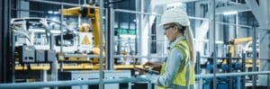 Car Factory: Female Automotive Engineer Wearing Hard Hat, Standi